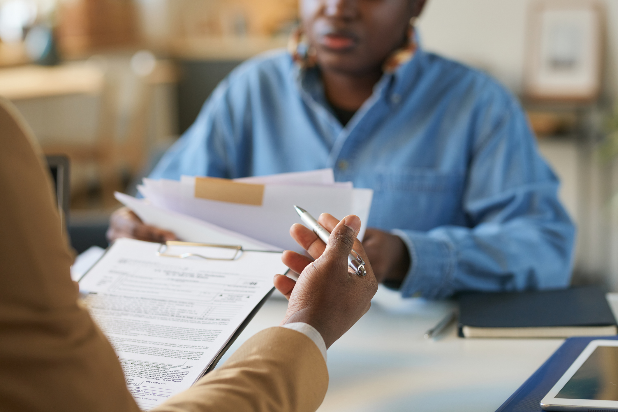 Male counselor meeting with female client, completing a questionnaire.